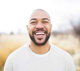 Man in white shirt smiling outside