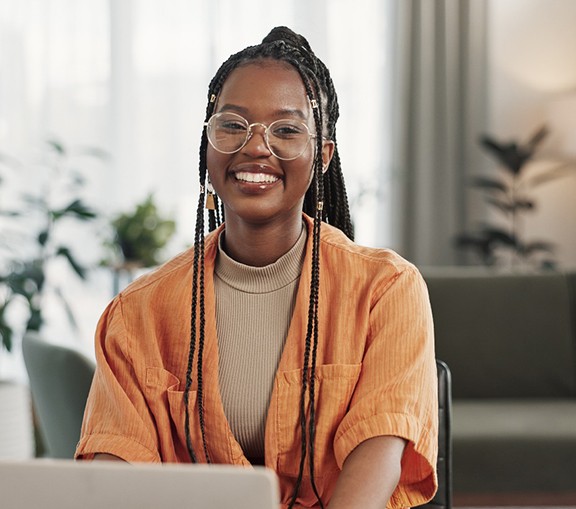 Woman smiling while working on laptop at home