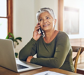 Smiling woman talking on phone at desk