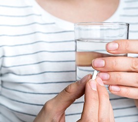 Woman preparing to swallow a pill